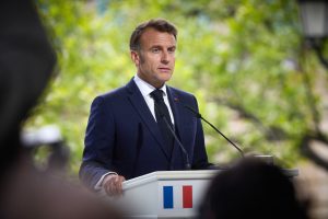 Francijas prezidents uzstājas preses konferencē pie tribīnes ar Francijas karoga simbolu