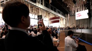 Apmeklētājs Japānā fotografē Latvijas karogu “Expo 2025 Osaka” pasākumā