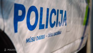 Policijas uzraksts uz dienesta transportlīdzekļa ar saukli “Mūsu darbs – jūsu drošībai”