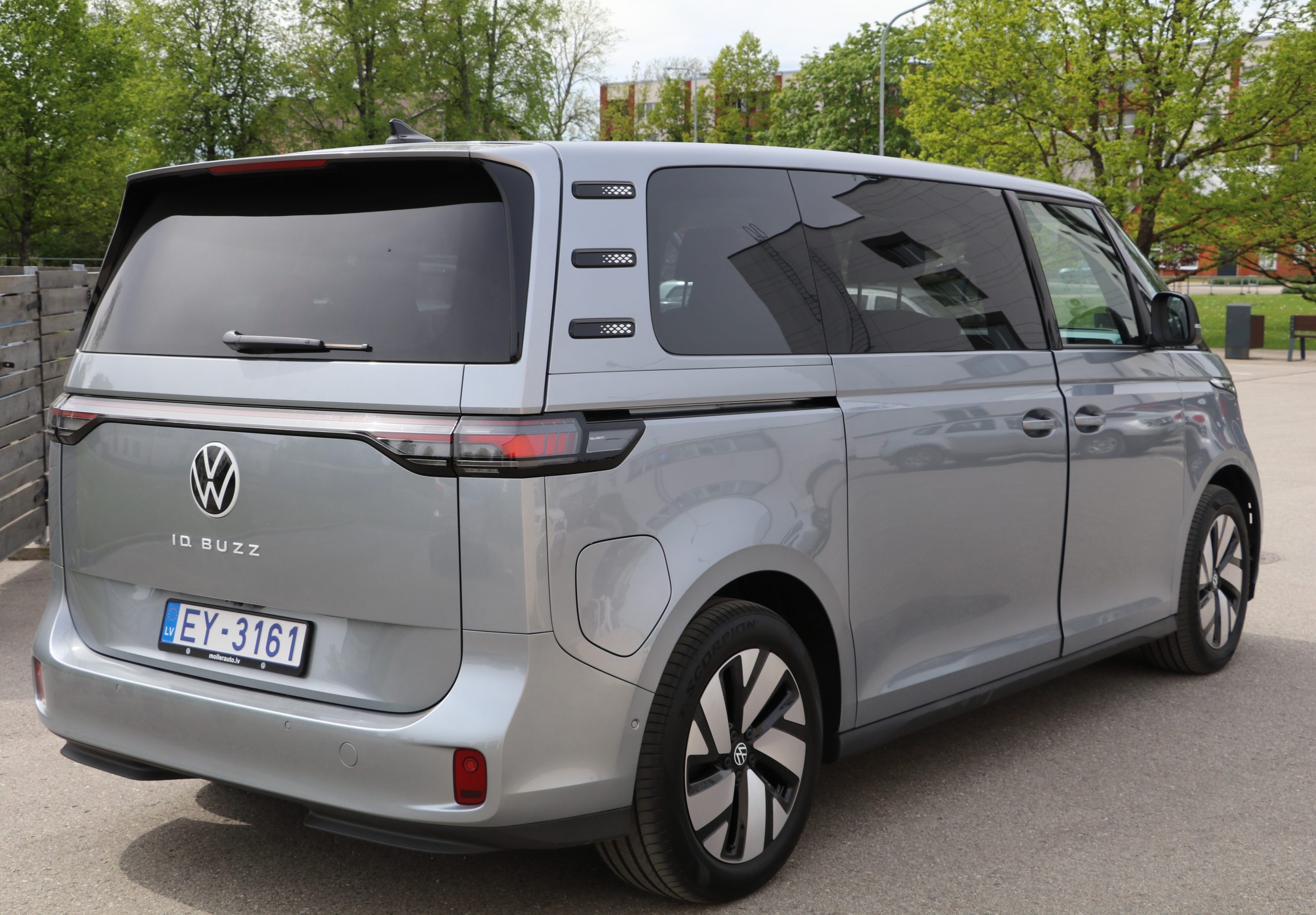 Sudraba krāsas Volkswagen ID. Buzz elektriskais minibuss stāvlaukumā