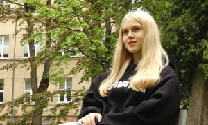 Skolniece Leona Fro no Vācijas sēž ārā pie skolas ēkas Valmierā