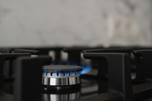 Dabasgāzes plīts ar zilganu liesmu virtuvē