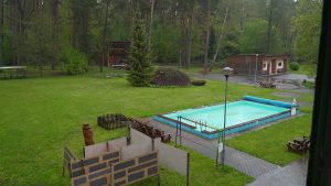 Vasaras nometnes teritorija ar baseinu, sporta laukumu un estrādi meža ielokā.