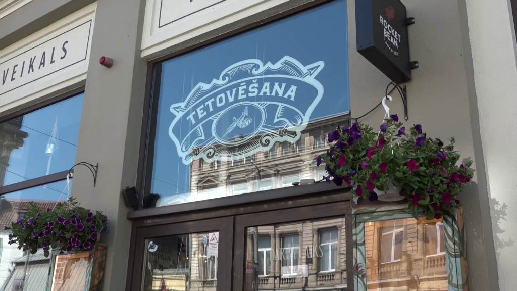 Logu uzlīme ar uzrakstu "TETOVĒŠANA" uz Voldemāra Valdmaņa salona Liepājā
