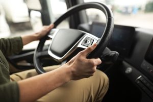 Autobusa vadītājas rokas uz stūres modernā transportlīdzeklī