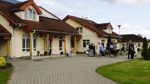 Valmieras SOS bērnu ciemata ēkas un pagalms ar cilvēku grupu