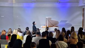 Pianists Andrejs Osokins uzstājas Ukrainā balta flīģeļa koncertā skatītāju priekšā.