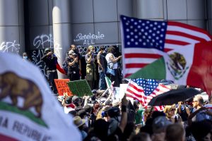 Protestētāji ar ASV, Meksikas un Kalifornijas karogiem demonstrācijā