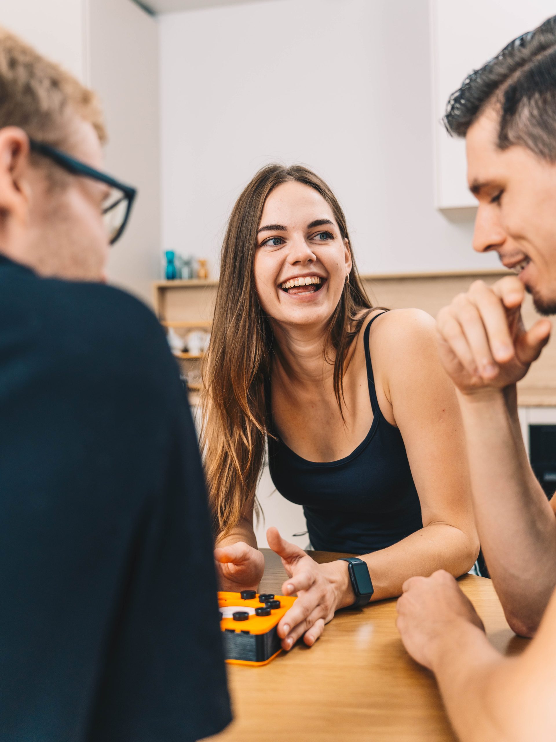 Jauna sieviete smaidot spēlē galda viktorīnas spēli “Smart 10”