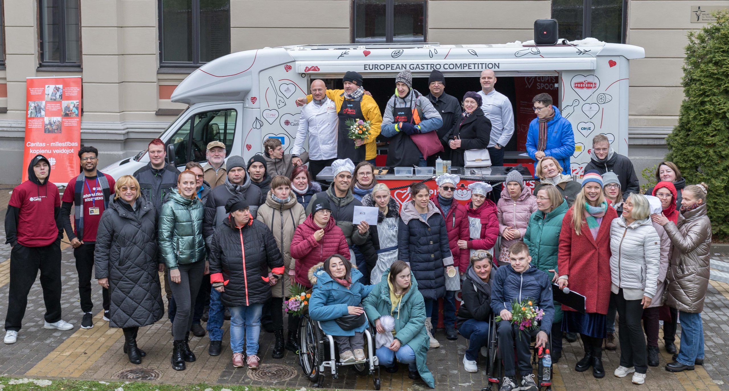 Dalībnieki un organizatori “Cupi’s Spoon” kulinārijas konkursā cilvēkiem ar īpašām vajadzībām pie Gastro busiņa Rīgā.