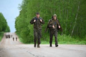 Divi karavīri formas tērpos soļo pa zemes ceļu “Zemitāna marša” laikā.