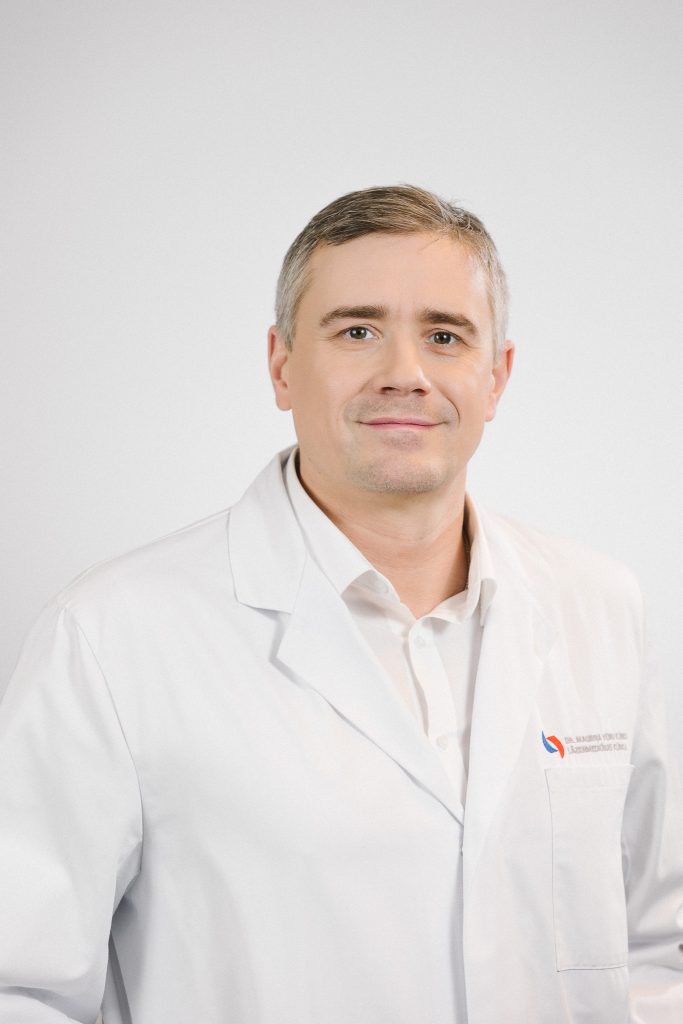 Dr. Andrejs Vanags baltā ārsta halātā – Dr. Mauriņa klīnikas Fleboloģijas nodaļas vadītājs.