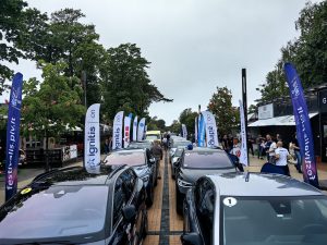 Elektroauto rinda un festivāla dalībnieki Jūrmalā.