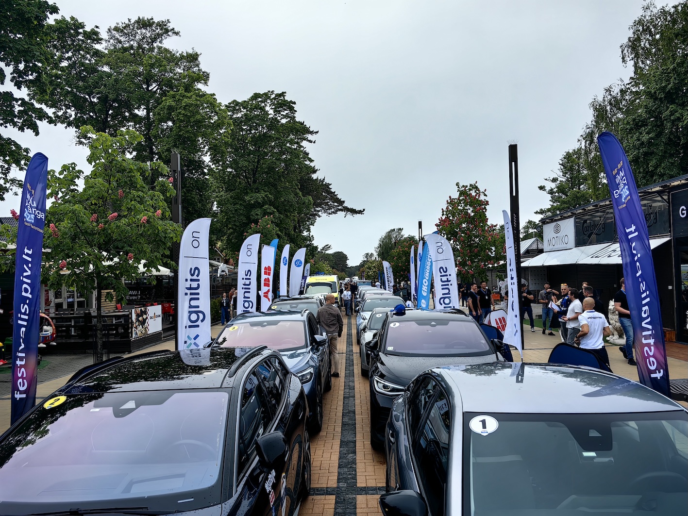 Elektroauto rinda un festivāla dalībnieki Jūrmalā.