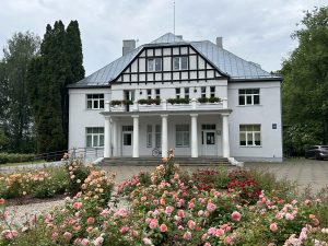 Ogresgala tautas nams vasarā ar rožu dobi priekšplānā