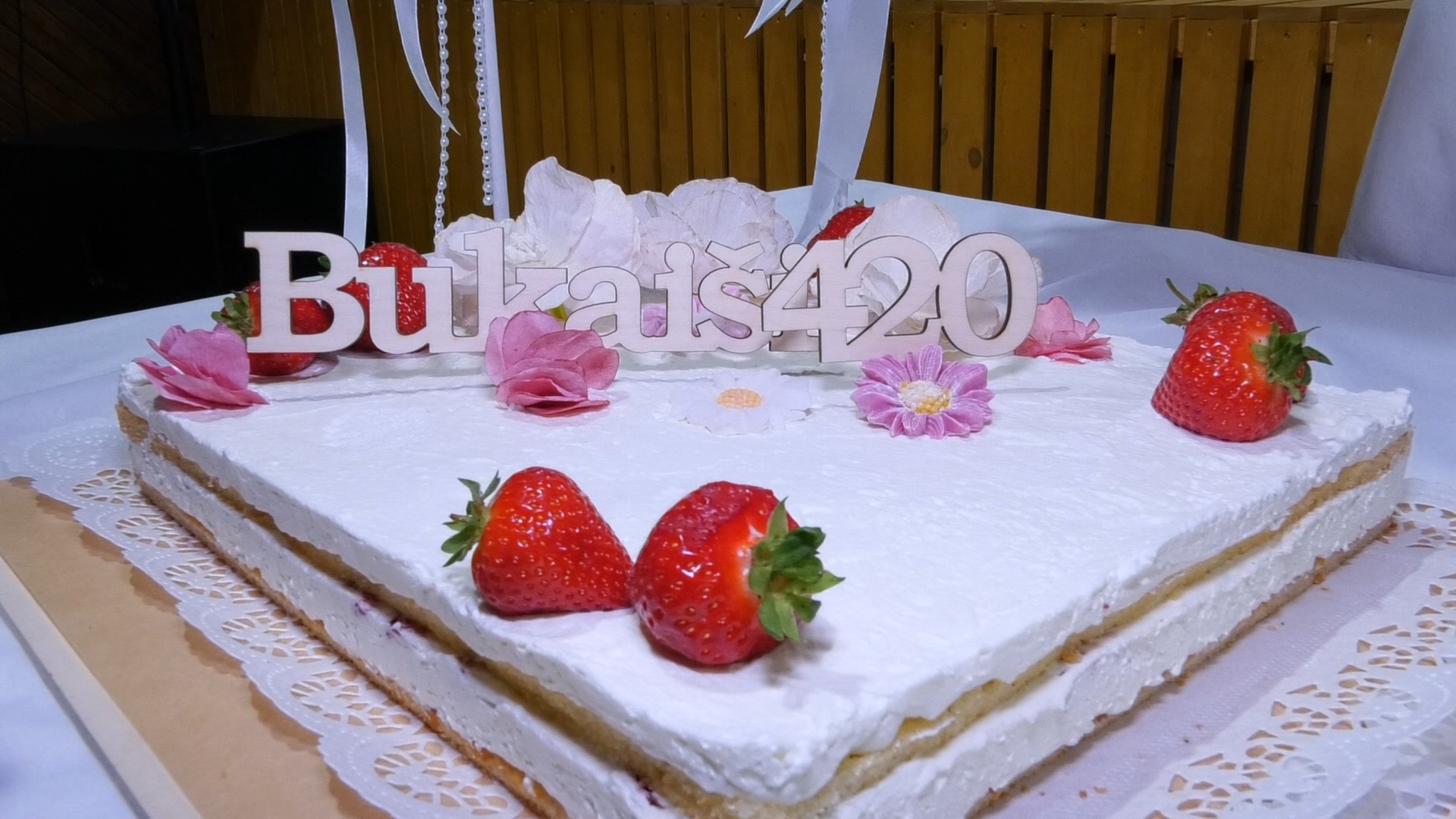 Baltā krējuma torte ar zemenēm un dekoru 