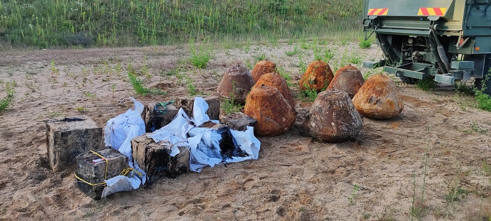 Atrasti militārie priekšmeti un metāla bloki smilšainā apvidū