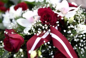 Ziedu vainags ar sarkanbaltsarkanu lentu Komunistiskā genocīda upuru piemiņai.
