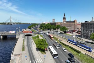 Rīgas centra satiksme ar autobusiem, tramvajiem un Vanšu tiltu fonā