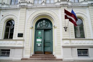 Rīgas Valsts ģimnāzijas ieeja ar vēlēšanu iecirkņa zīmi un Latvijas karogu