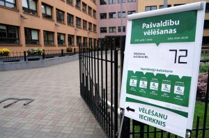 Vēlēšanu iecirkņa zīme pie ieejas ēkā ar norādēm par pašvaldību vēlēšanu datumiem