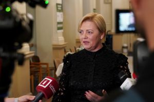 Kristīne Saulīte sniedz interviju žurnālistiem pēc komisijas sēdes, mikrofonos redzami LTV, LETA un citi logotipi.