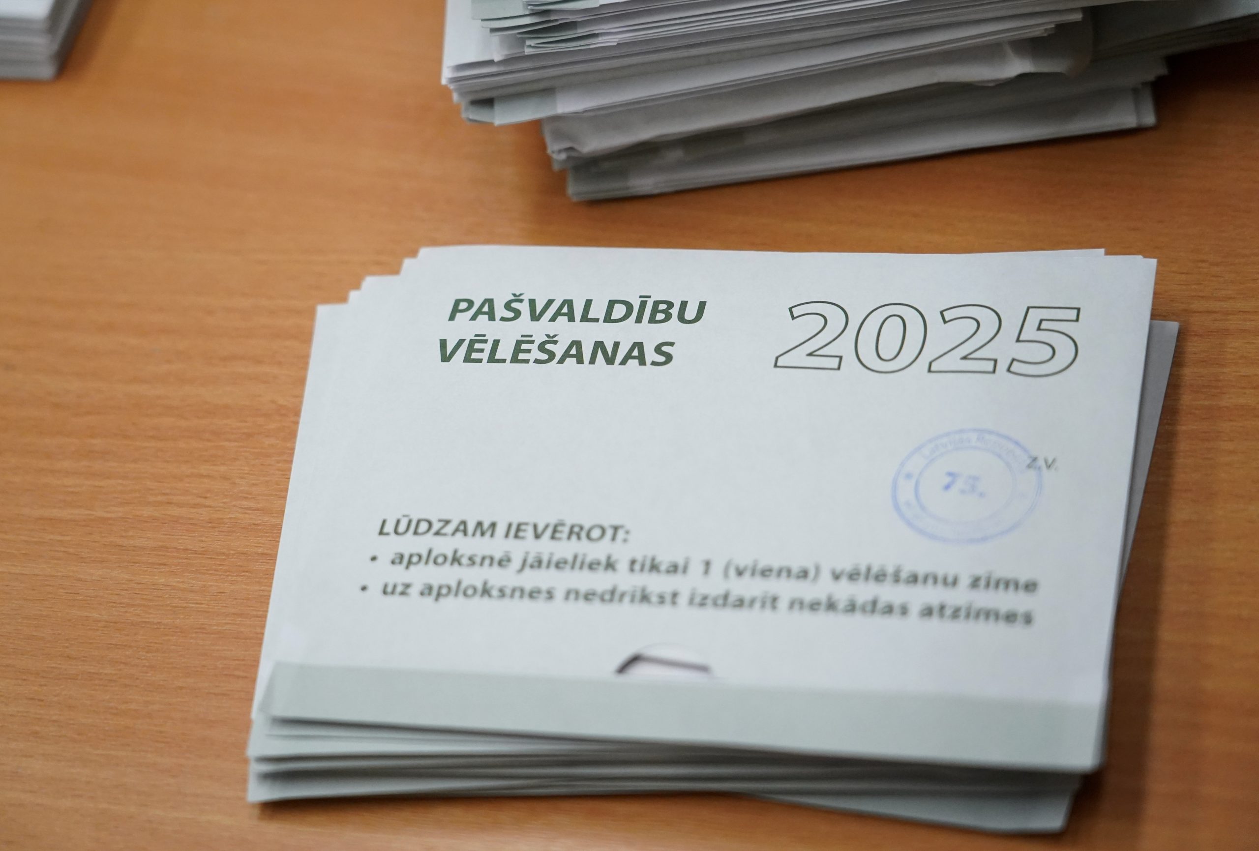 Pašvaldību vēlēšanu aploksnes ar 2025. gada atzīmi uz galda