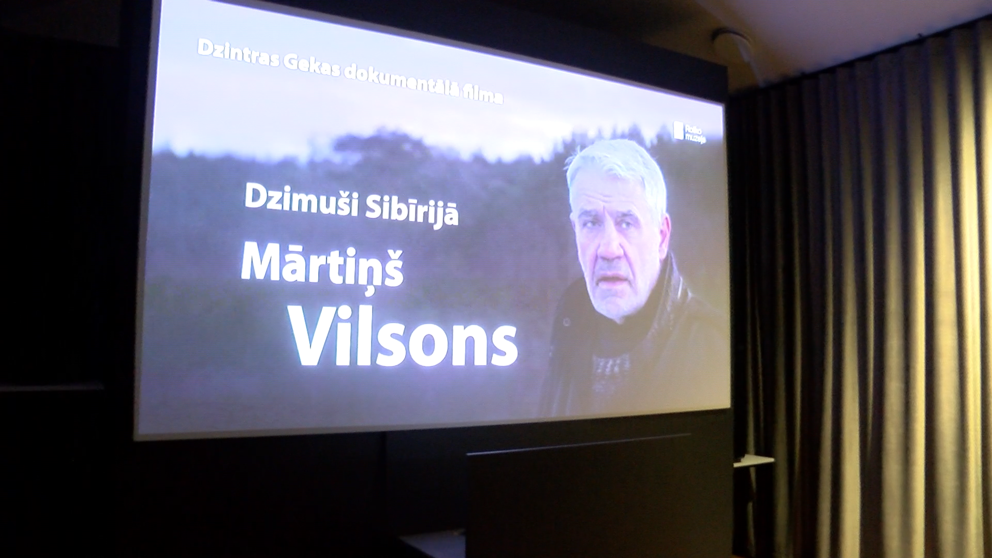 Ekrānā redzams dokumentālās filmas “Dzimusi Sibīrijā. Mārtiņš Vilsons” tituls ar galvenā varoņa portretu