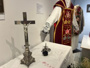 Krusts ar Jēzus tēlu un izšūts garīdznieka tērps izstādē