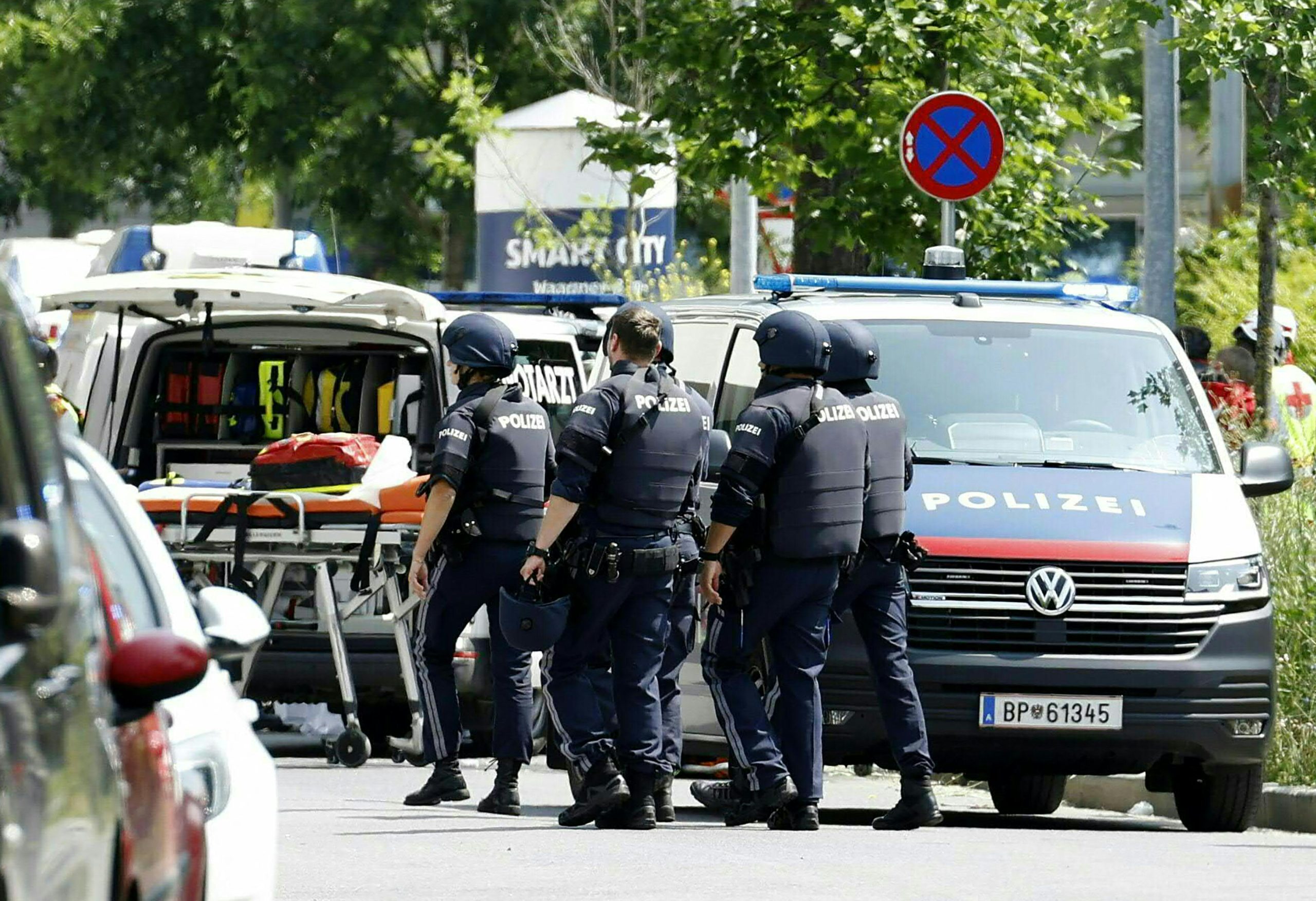 Policijas darbinieki stāv pie policijas busiņa apšaudes vietā Grācā, Austrijā