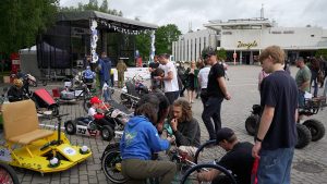 Tehnoloģiju festivāla apmeklētāji apskata un sagatavo pašbūvētus transportlīdzekļus sacensībām pie T/C "Zemgale"