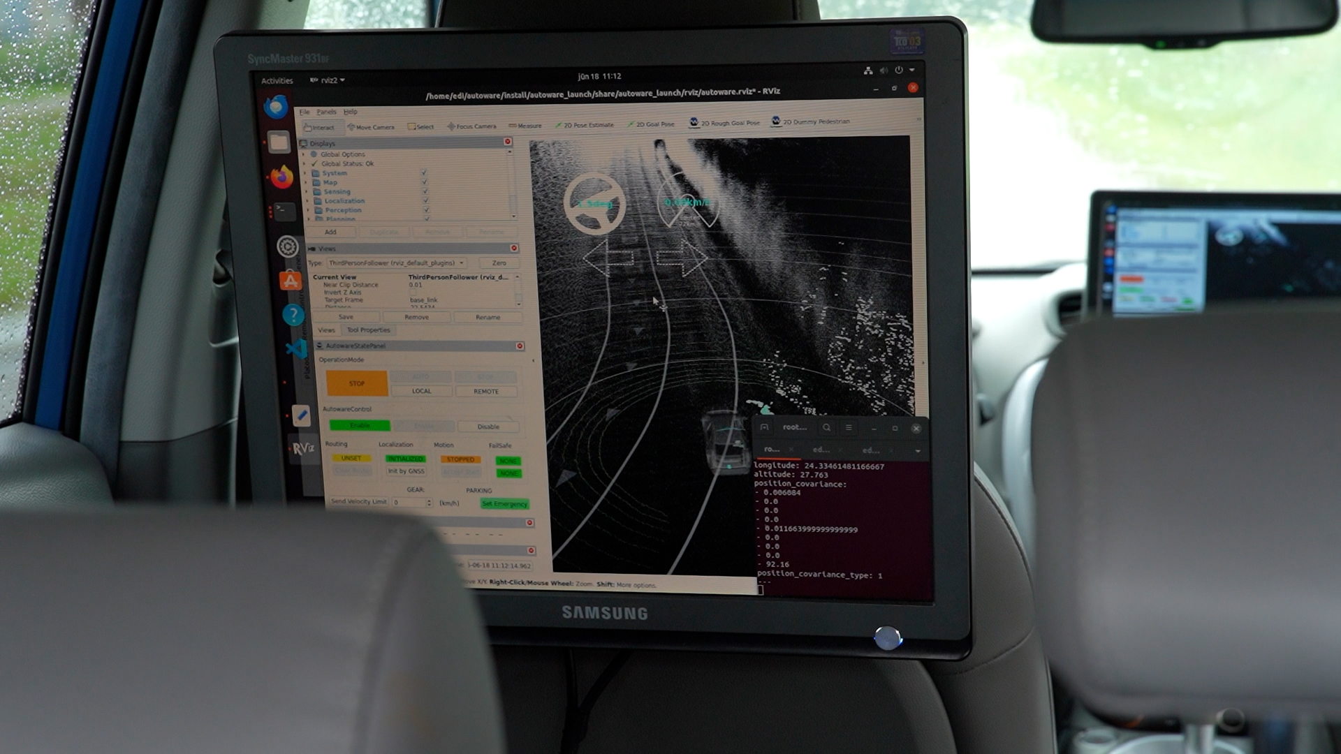 Auto salonā uz monitora redzams navigācijas un sensoru datu attēlojums, vizualizējot ceļu un apkārtni