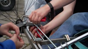 Rokas ar instrumentiem skrūvē paštaisīta transportlīdzekļa riteņa konstrukciju