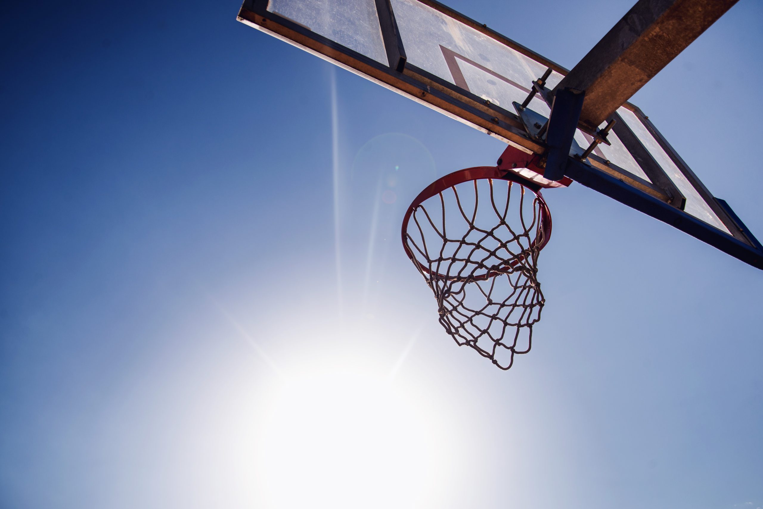 Basketbola grozs pret zilām debesīm un spilgtu sauli