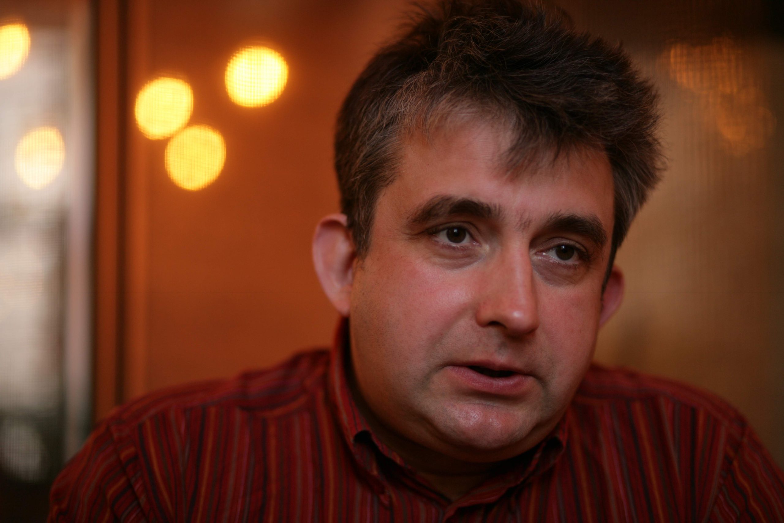Aktieris Gundars Āboliņš sēž un skatās ar nopietnu sejas izteiksmi