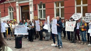 Cilvēku grupa ar plakātiem pulcējusies piketā pie Saeimas ēkas Rīgā, protestējot par tālmācības pieejamību.