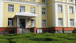 Gaiši dzeltena ēka ar uzrakstu "VESELĪBAS CENTRS BASTIONS" virs ieejas Valmierā