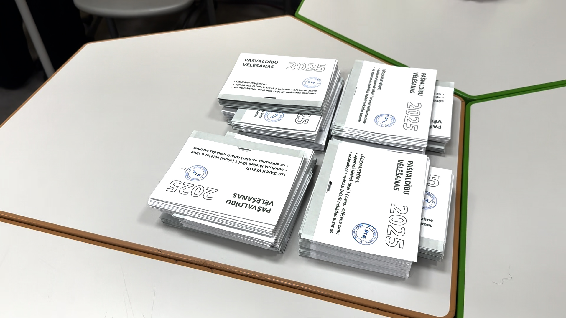 Pašvaldību vēlēšanu 2025. gada balsošanas zīmju saiņi uz galda
