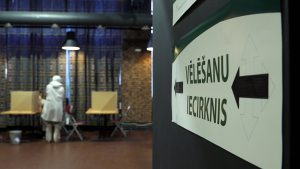 Sieviete balsošanas iecirknī pie vēlēšanu kabīnēm