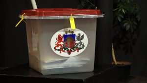 Balsu urna ar Latvijas valsts ģerboni vēlēšanu iecirknī
