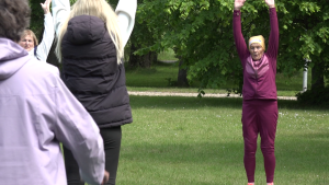 Senioru vingrošana brīvā dabā Liepājā, dāmas veic stiepšanās vingrinājumus.