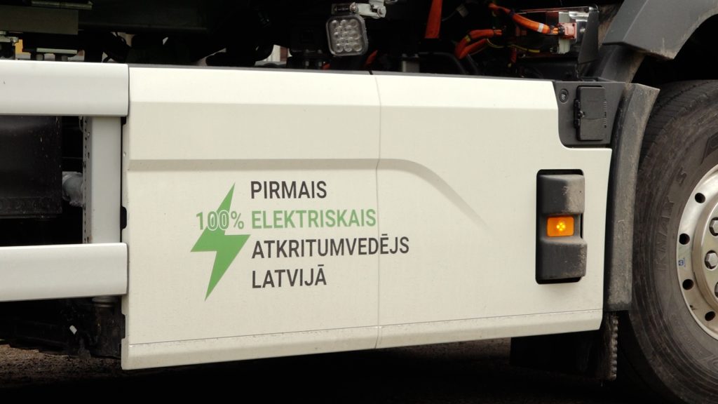 Detalizēts uzraksts uz ZAAO elektriskā atkritumu vedēja sāniem: "PIRMAIS 100% ELEKTRISKAIS ATKRITUMVEDĒJS LATVIJĀ"