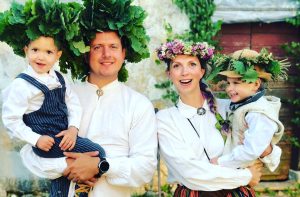 Ģimene latviešu tautastērpos ar ozollapu un ziedu vainagiem Jāņu svinībās