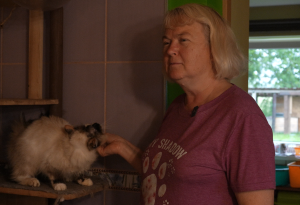 Sieviete glauda pūkainu kaķi telpā