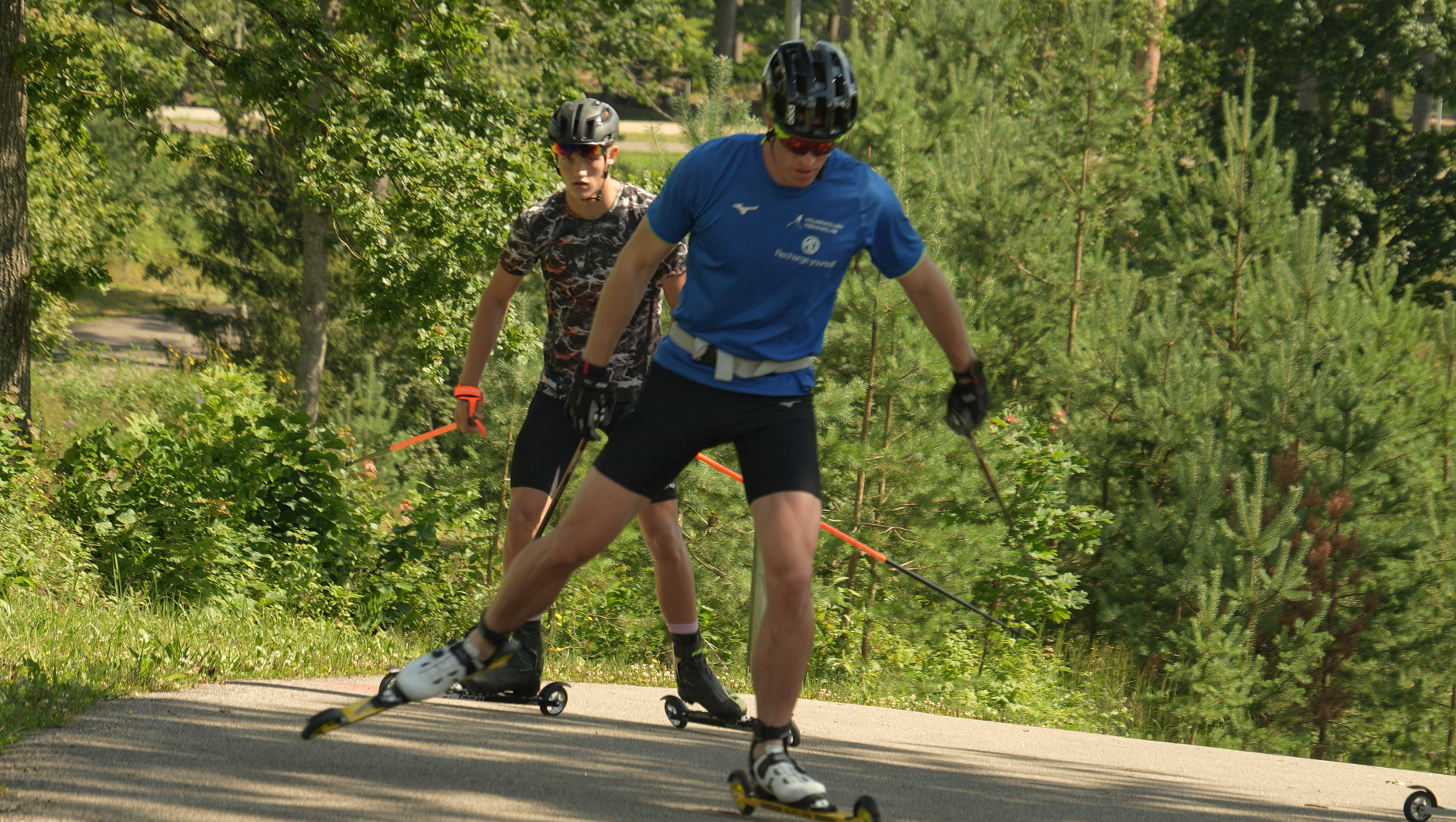 Divi rollerslēpotāji treniņa laikā Madonā pirms Pasaules kausa sacensībām.