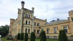Gārsenes pils fasāde ar torņiem un stārķa ligzdu.