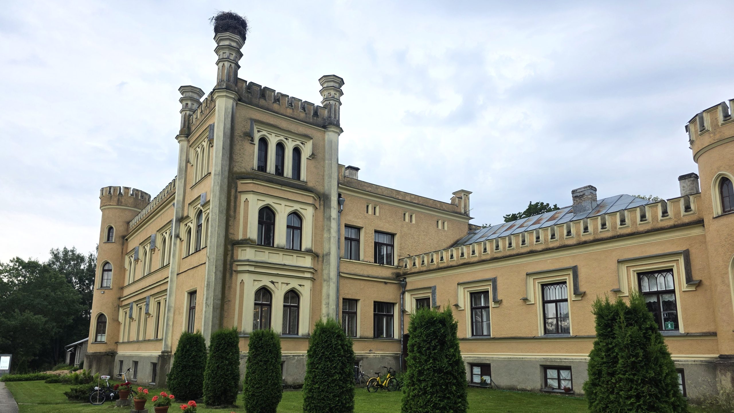 Gārsenes pils fasāde ar torņiem un stārķa ligzdu.