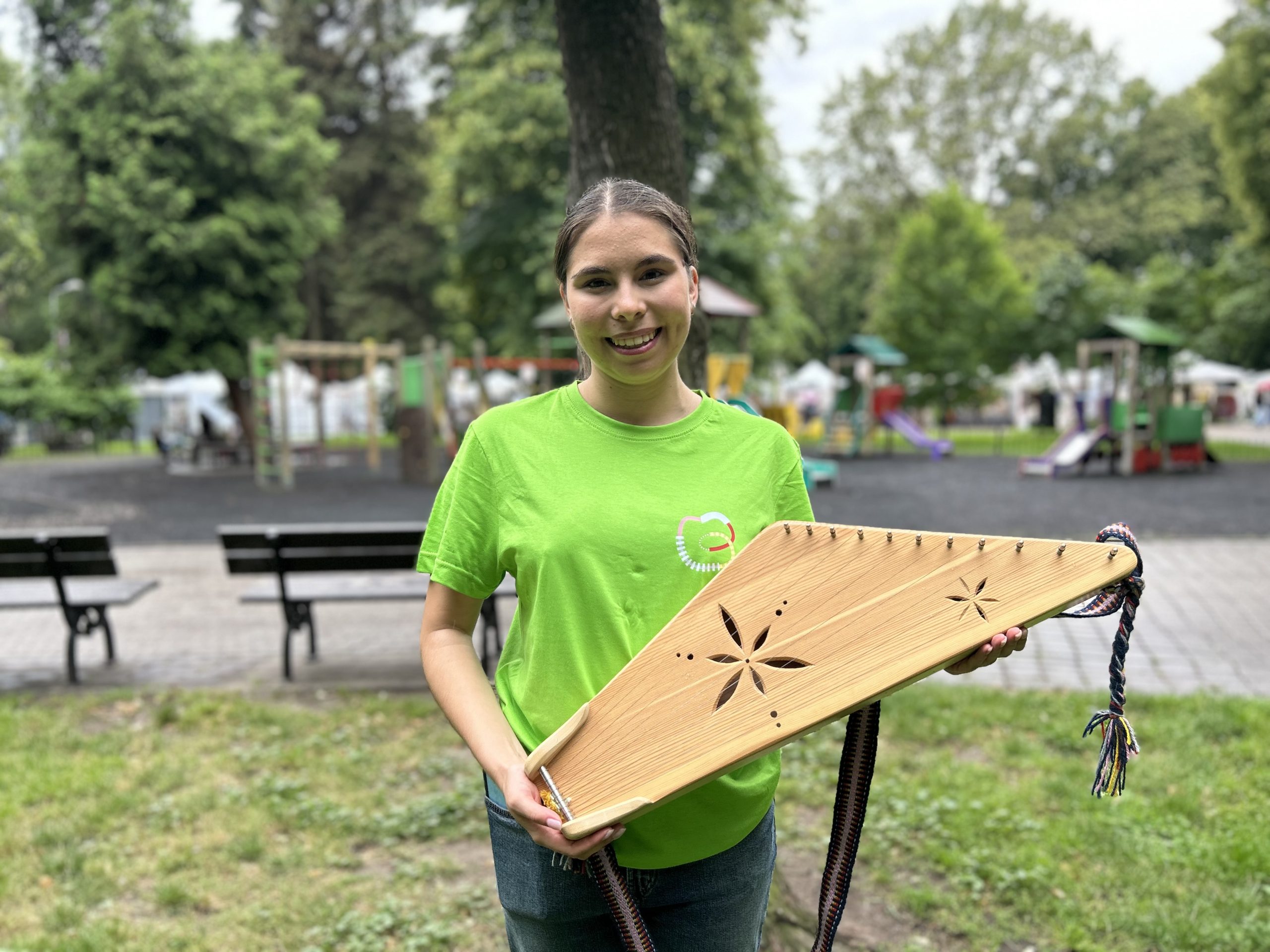 Jauna sieviete parkā tur rokās kokli