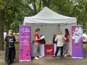 Study in Latvia informatīvais stends parkā ar apmeklētājiem