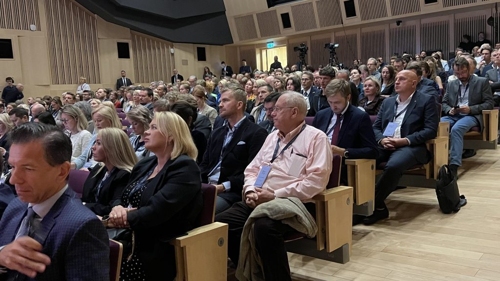 Foruma dalībnieki sēž auditorijā un uzmanīgi klausās prezentācijās